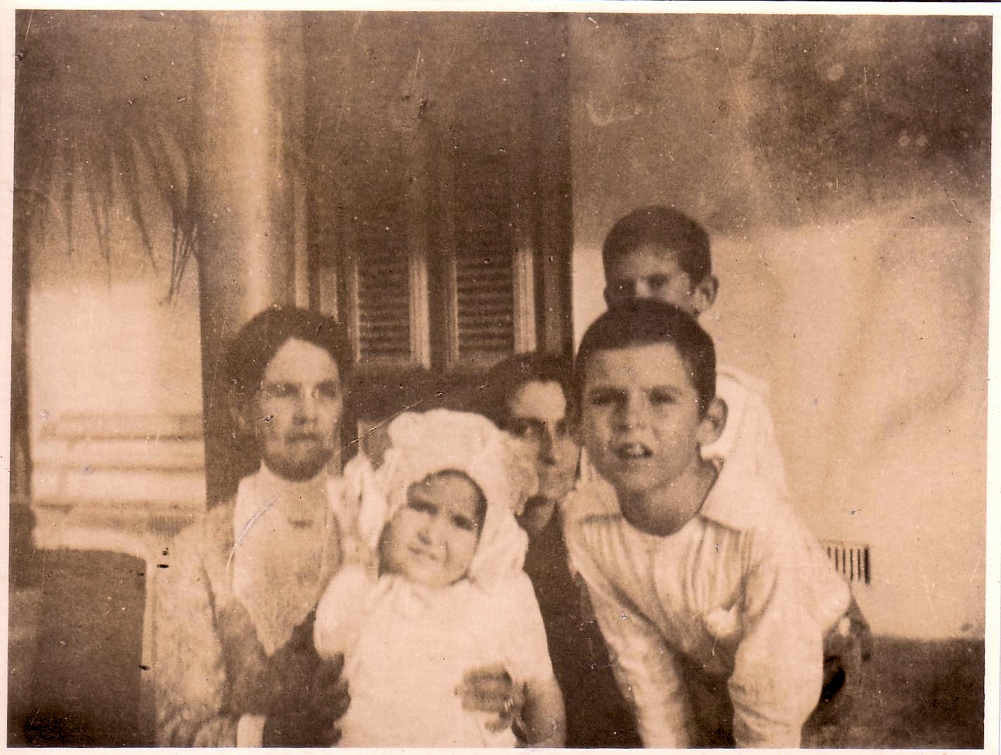 L-R: Granny Foster, Hilda Gitens, Annie (Foster) Gittens peeping through between Hild's bonnett and Edgar Clement Gittens right ear, Ivan Gittens looking over Egar's head